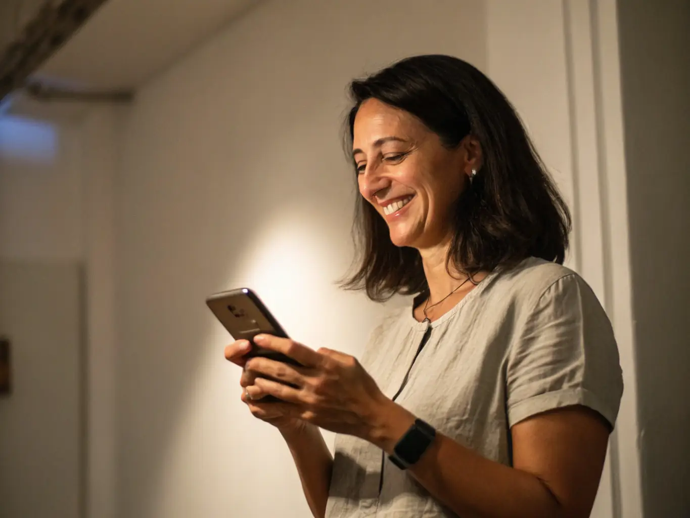 A young Indian professional using a budgeting app on their smartphone, smiling confidently. The background shows a modern apartment, symbolizing financial stability.